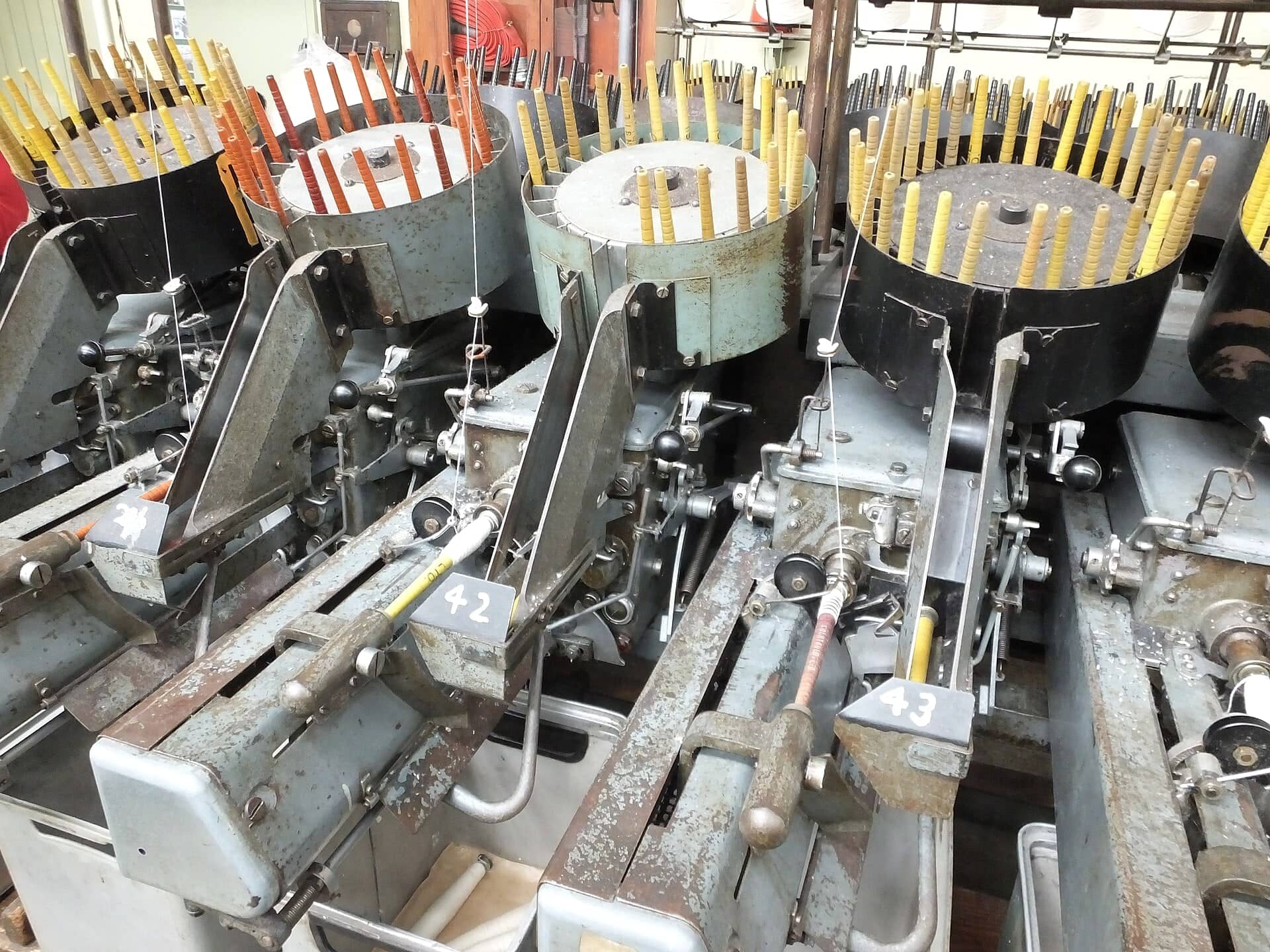 Winding machines loaded with bobbins inside a textile mill